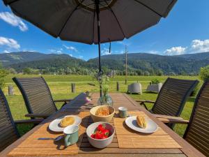 a wooden table with food on it with an umbrella at Rattendorf 23A in Rattendorf