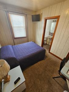 a bedroom with a purple bed and a mirror at Lewiston Hotel Bar & Grill in Lewiston