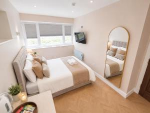 a bedroom with two beds and a mirror at Hayes Studios near Heathrow in Northolt