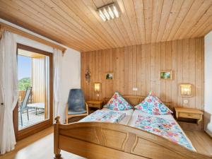 a bedroom with a bed and a chair and a window at Hans in Waldkirchen