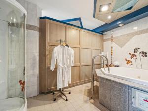 a bathroom with a tub and a robe on a rack at Hans in Waldkirchen +21 photos
