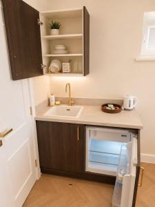 a small kitchen with a sink and a dishwasher at Hayes Studios near Heathrow in Northolt +13 photos
