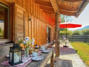 a table on the porch of a house with an umbrella at Trebas 51 in Lake Pressegg