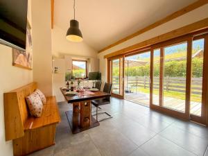 a dining room with a table and a glass door at Bellone 52 in Lake Pressegg
