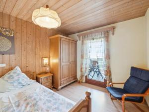 a bedroom with a bed and a chair and a window at Traudi in Waldkirchen