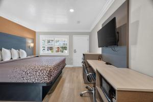 a hotel room with a bed and a flat screen tv at Padre Oaks in Monterey