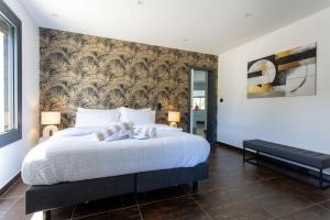 a bedroom with a large white bed with a wall at Bien plus qu un séjour Une expérience à vivre in Mondragon +49 photos