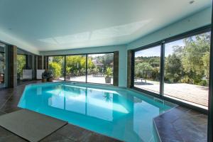 an indoor swimming pool in a house with large windows at Bien plus qu un séjour Une expérience à vivre in Mondragon