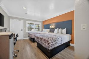 a hotel room with two beds and a kitchen at Padre Oaks in Monterey