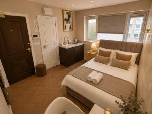 a bedroom with a large bed and a bathroom at Hayes Studios near Heathrow in Northolt