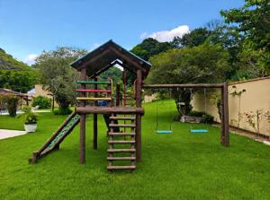 a playground with a slide and a play house at Chácara no centro para até 15 pessoas com piscina aquecida e 5 quartos in Duas Barras