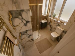 a bathroom with a shower and a toilet and a sink at Hayes Studios near Heathrow in Northolt