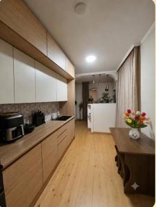 a kitchen with white cabinets and a wooden table at Qristi's Guest House in Kashveti