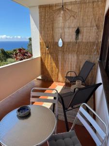 a room with a table and chairs on a balcony at Apartamentos Matur in Machico