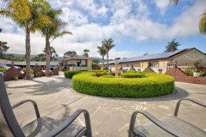 a couple of chairs in a courtyard with palm trees at Padre Oaks in Monterey