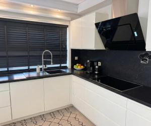 a kitchen with white cabinets and a black counter top at Negenendertigtwintig-Lommel in Lommel
