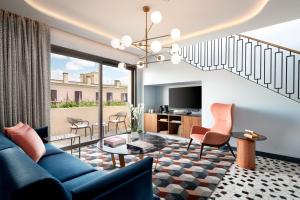 a living room with a blue couch and chairs at Le Meridien Visconti Rome in Rome