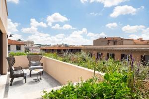 two chairs and a table on a balcony with plants at Le Meridien Visconti Rome in Rome