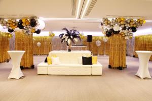 a room with a white couch and a stage with balloons at Le Meridien Visconti Rome in Rome