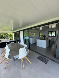 a dining room with a table and white chairs at Teahupoo MANA VILLA in Toanoano