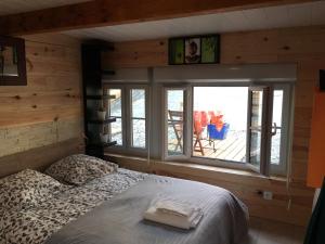 a bedroom with a bed and a large window at La Palissandre in Tallard