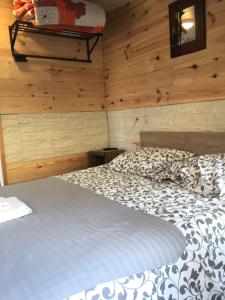 a bedroom with a bed in a room with wooden walls at La Palissandre in Tallard
