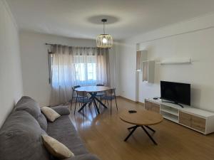 a living room with a couch and a table at Renna in Corroios