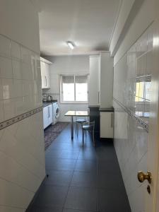 a kitchen with a table and a dining room at Renna in Corroios