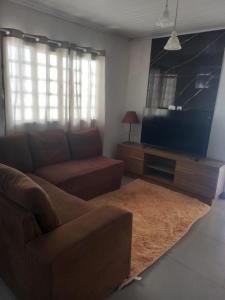 a living room with a couch and a flat screen tv at Casa proxima ABQM in Araçatuba