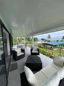 a living room with white furniture and a view of the ocean at Teahupoo MANA VILLA in Toanoano