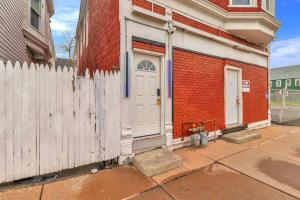 a red brick house with a white door and a fence at 4BR Apt Pool Table Sleeps 9 Buffalo in Buffalo
