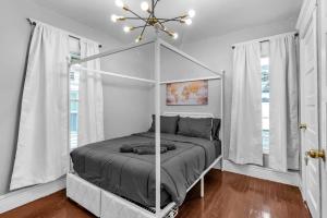 a bedroom with a canopy bed and windows at 4BR Apt Pool Table Sleeps 9 Buffalo in Buffalo