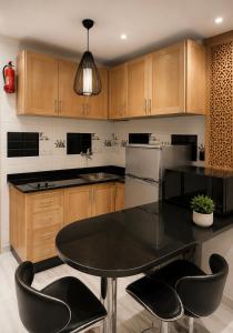 a kitchen with a black table and black chairs at Modern Studio Hassan Rabat in Rabat