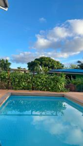 a pool with blue water in front of a building at Teahupoo MANA VILLA in Toanoano