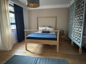 a bedroom with a bed with a blue comforter at El cuarto AZUL in Urrugne +3 photos