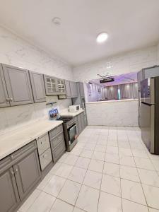 a large kitchen with white tile floors and appliances at شاليه درة العروس البرادايس بيتش in Dahaban