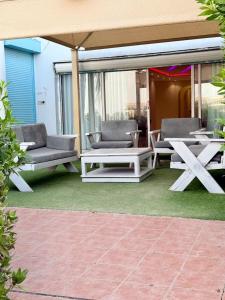 a patio with chairs and tables and an umbrella at شاليه درة العروس البرادايس بيتش in Dahaban