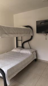 a bedroom with two bunk beds and a tv at Apartamento Raúl Melendez Ámbar Villeta in Villeta +8 photos