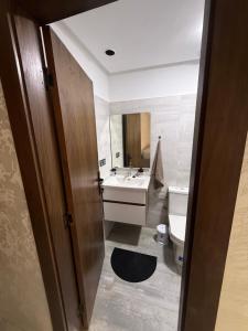 a bathroom with a sink and a toilet and a mirror at Appartement avec balcon vue sur forêt - centre ville in Ifrane +10 photos