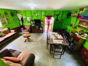 a living room with green walls and a table at Casa cerca de IRTRA in San Martín Zapotitlán