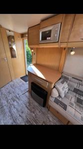 a small room with a desk and a microwave at Кемпер дом in Chişinău