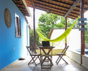 a patio with a hammock and a table and chairs at A Casa Azul in Barra Grande