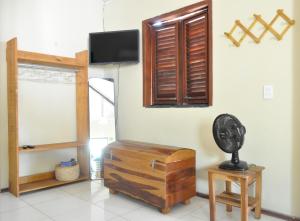 a living room with a tv and a wooden chest at A Casa Azul in Barra Grande