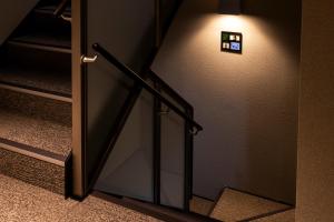 a stairway with a light on the wall and a stair case at GRAND BASE Peace Park in Nagasaki