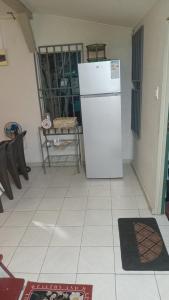 a kitchen with a white refrigerator in a room at Tiny house in Paramaribo +2 photos