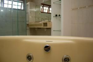a bathroom with a tub and a sink and a mirror at Hostel Terraço Urbano in Sao Jose do Rio Preto +51 photos
