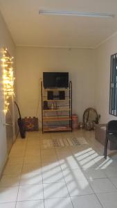 a living room with a flat screen tv on a stand at Tiny house in Paramaribo