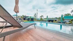 a swimming pool with a chair and an umbrella at RMB's Downton Place in Tagaytay