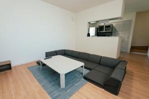a living room with a couch and a table at ビアンカ Bianca A号室 in Asahikawa
