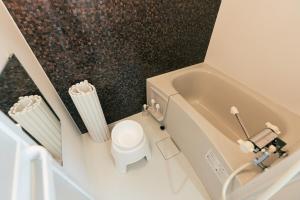 a small bathroom with a toilet and a bath tub at ビアンカ Bianca A号室 in Asahikawa